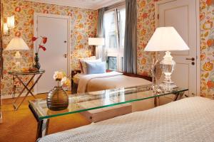 a hotel room with two beds and a glass table at Hotel Estheréa in Amsterdam