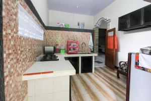 a kitchen with a brick wall and a counter at RedDoorz near Museum Gunung Merapi in Yogyakarta