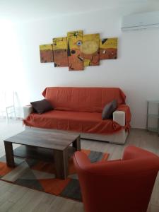 a living room with a red couch and a table at Casa Vacanze La Pintadera in SantʼAntìoco