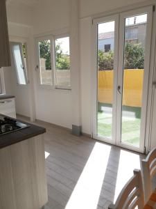 a kitchen with sliding glass doors and a kitchen with at Casa Vacanze La Pintadera in SantʼAntìoco