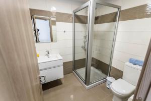 a bathroom with a shower and a toilet and a sink at Bellini Hotel in Ayia Napa