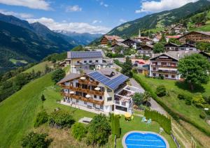 シェーナにあるGasserhof Garni & Apartmentの山間の住宅地にソーラーパネルが設置されている