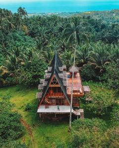 una pequeña casa en un campo con palmeras en Camiguin Volcano Houses - A-Frame house, en Mambajao