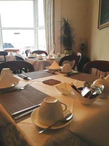 a table with plates and utensils on top of it at Malvern House in Portrush