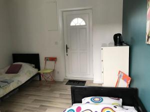 Schlafzimmer mit einem Bett, einem Kühlschrank und einer Tür in der Unterkunft Chambre indépendante avec SDB-Terrasse privative. Centre ville in Nîmes