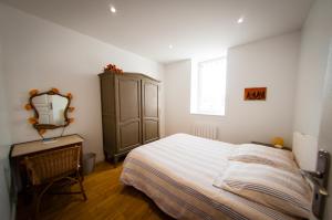 ヴィシーにあるLe Massiliaのベッドルーム1室(ベッド1台、鏡、ドレッサー付)