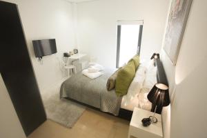 een kleine witte slaapkamer met een bed en een raam bij Room Home Stay in Londen