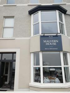 a building with a sign for a maywegian house at Malvern House in Portrush