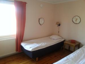 a small room with a bed and a window at Havsbandet Pensionat in Eckerö