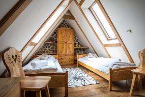 two beds in a attic room with skylights at Apartamenty Pod Dachem w Centrum APARTZAKOP in Zakopane