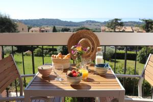 einen Tisch mit Speisen und Obst auf dem Balkon in der Unterkunft Le Petit Vue Mer in La Croix-Valmer