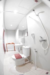 La salle de bains blanche est pourvue de toilettes et d'un lavabo. dans l'établissement Bale Ocasa, à Tangerang