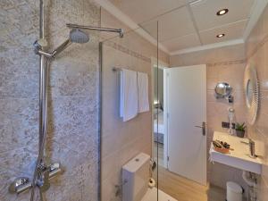 uma casa de banho com um chuveiro e uma porta de vidro em Paguera Treff Boutique Hotel em Paguera