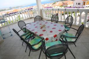 een tafel en stoelen op een balkon met uitzicht op de oceaan bij Apartments Katarine Zrinske in Vodice