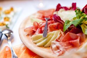 un plato de comida con carne y verduras en una mesa en Waldhotel Linzmühle, en Kahla