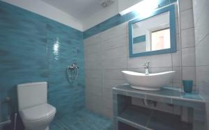 La salle de bains est pourvue d'un lavabo, de toilettes et d'un miroir. dans l'établissement Panos Studios, à Massouri