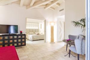 a living room with a television and a table and chairs at Corte Bianca - Adults Only & SPA - Bovis Hotels in Cardedu