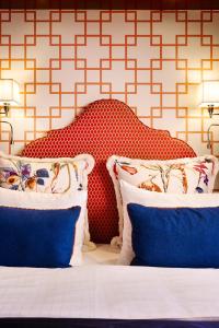 a bedroom with a bed with a red headboard and blue pillows at Hotel Estheréa in Amsterdam