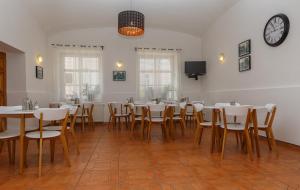 a dining room with tables and chairs and a clock on the wall at Hotel Richmond Teplice in Teplice