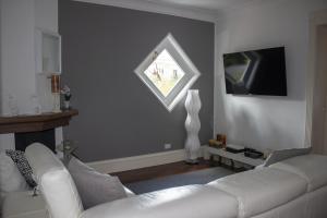 un soggiorno con divano bianco e finestra di Villa Degli Ulivi a Mondello