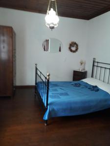 扎戈拉的住宿－維拉傳統房屋酒店，一间卧室配有蓝色的床和吊灯。