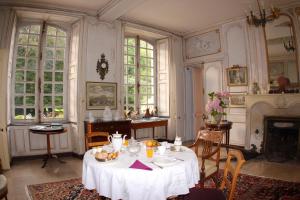 a dining room with a table and a fireplace at Chateau de Flottemanville in Flottemanville