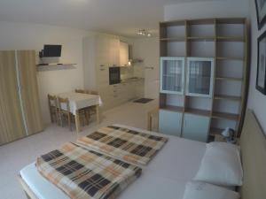 1 dormitorio con 1 cama, cocina y mesa en Monolocale Colombo - Agenzia Cocal, en Caorle