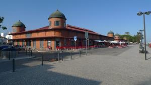 un grande edificio in mattoni con sedie rosse di fronte di Sovipral Homes Casa Marina a Olhão