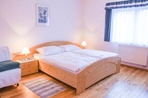 a bedroom with a wooden bed and a window at Haus Lenz Ferienwohnungen - Fam Ostermann in Puchberg am Schneeberg