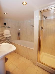 a bathroom with a tub and a sink and a shower at 4 Lomond Castle in Balloch