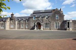 un grande edificio in pietra con un grande vialetto di 4 Lomond Castle a Balloch