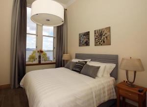 - une chambre avec un lit blanc et une fenêtre dans l'établissement 4 Lomond Castle, à Balloch