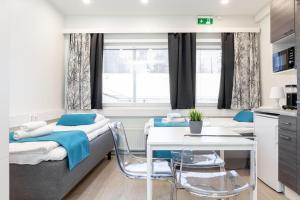 a room with a bed and a table and chairs at Oma Hotelli in Ylöjärvi