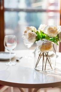 eine Vase voller weißer Blumen auf dem Tisch in der Unterkunft Apartments Warsaw Grzybowska by Renters in Warschau