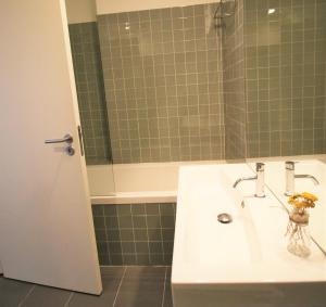 uma casa de banho com um lavatório branco e um espelho. em ALIADOS by YoursPorto em Porto