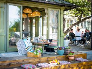 a porch with a table and chairs and people sitting at STF Långholmen Hostel Beds in Stockholm