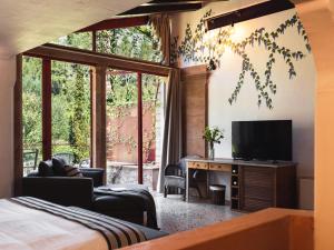 une chambre avec un lit, une télévision et une fenêtre dans l'établissement Hotel Finca Ca N'ai - Adults Only, à Sóller