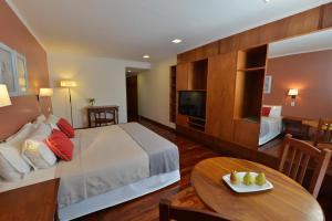 a hotel room with a bed and a table at Hotel Saint George in Puerto Iguazú