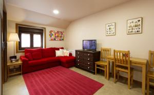 sala de estar con sofá rojo y mesa en Casa A Marchanta, en Poio