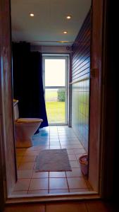 uma casa de banho com WC e uma porta com janela em Wingårdhs B&B Österlen em Löderup
