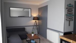 - un salon avec un canapé et un miroir dans l'établissement COUCHANT RADIEUX Appartement 2 pièces 4 personnes vue mer, à Saint-Jean-de-Monts