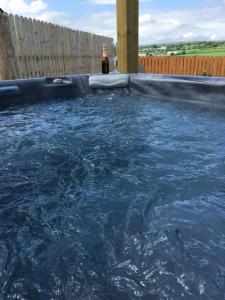 a pool of water with a bottle of beer in it at Roe Valley Cottage - LA Spa Hot Tub in Limavady