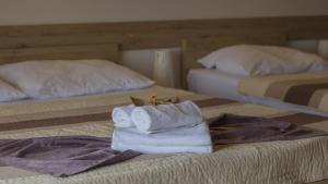 a hotel room with two beds with towels on a bed at Resort Big House Plitvička jezera in Ličko Petrovo Selo