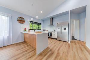 uma cozinha com electrodomésticos brancos e piso em madeira em Hillside Haven - Airlie Beach em Airlie Beach