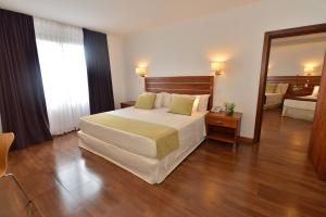 a bedroom with a large bed and a mirror at Hotel Saint George in Puerto Iguazú