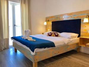 a bedroom with a large bed with a wooden headboard at Boho House in Pakoštane