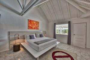 a bedroom with a large bed and a large window at Dream Villa Terres Basses 540 in Les Terres Basses