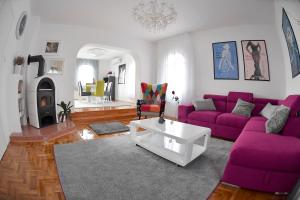a living room with purple couches and a fireplace at My Day House App1 in Klenovica