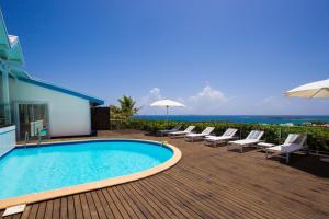 a swimming pool on a deck with chairs and umbrellas at Dream Villa Orient Bay 570 in Orient Bay