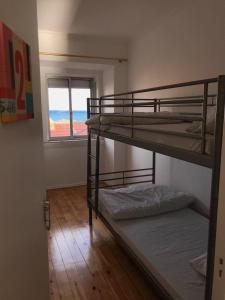 een kamer met 3 stapelbedden en een raam bij Auristelas Hostel in Lissabon